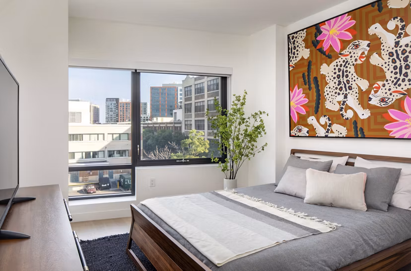 Cozy bedroom with modern decor at Bower Apartments offering luxury living in an exclusive community