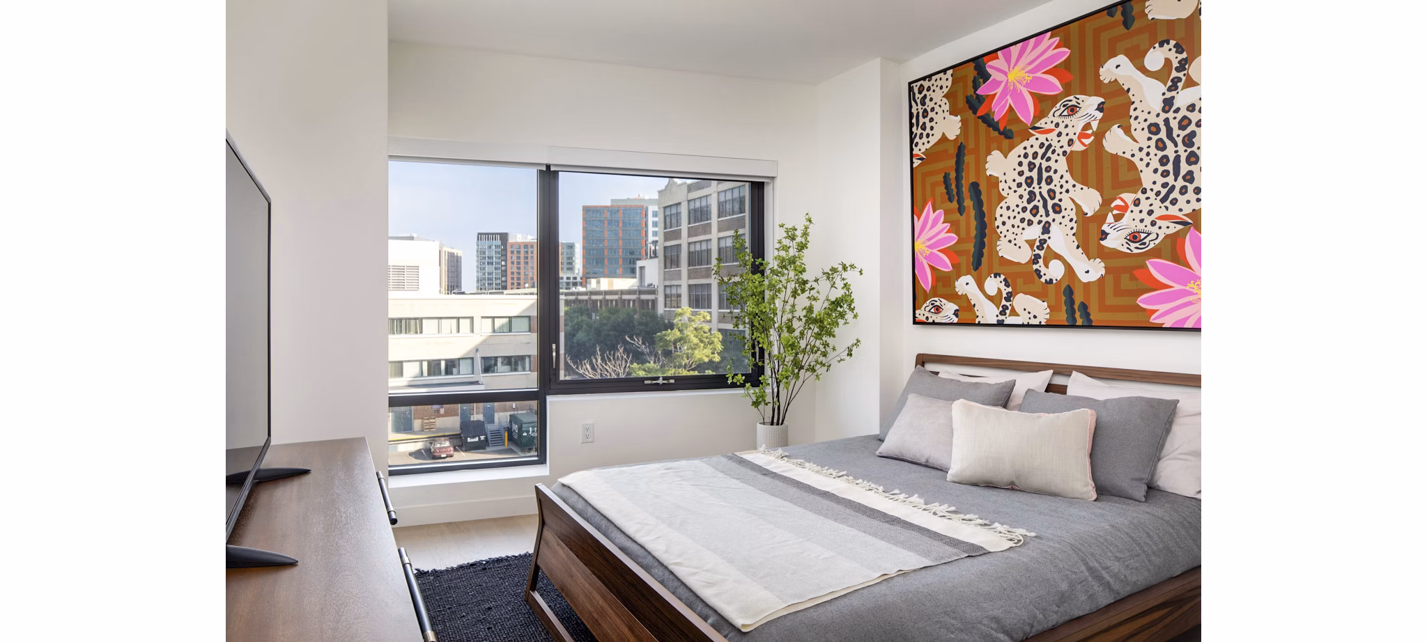 Cozy bedroom with modern decor at Bower Apartments offering luxury living in an exclusive community