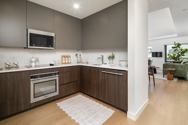 Modern kitchen featuring sleek countertops and stainless steel appliances in Bower Apartments