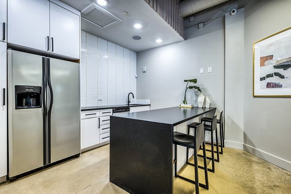 Modern kitchen with stainless steel appliances and granite countertops at Inspire Downtown Apartments