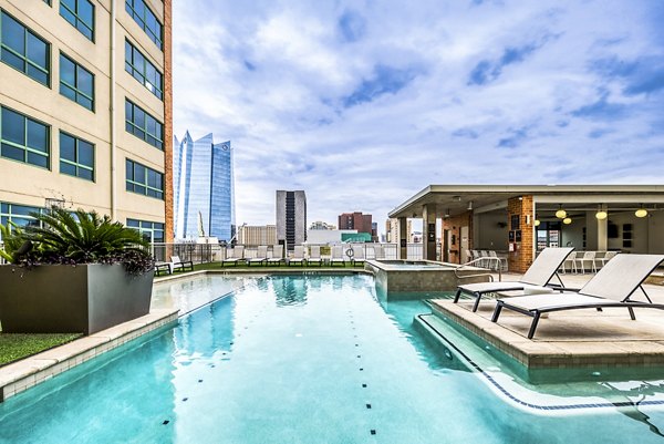 Rooftop pool with lounge chairs at Inspire Downtown Apartments offering skyline views