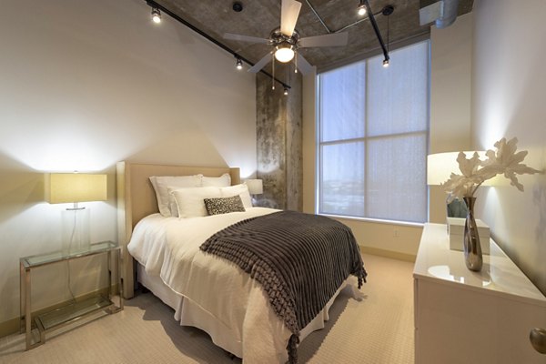 Cozy bedroom with minimalist decor and city views at The Museum Tower Apartments