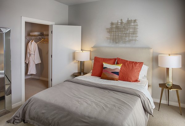 Cozy queen-size bed and modern decor in a bedroom at South Main Station Apartments