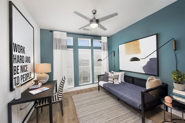 Cozy bedroom with modern decor and large windows at The Penrose Apartments