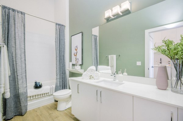 Modern bathroom with marble countertops and glass shower in The Penrose Apartments, luxury living in a prime urban setting