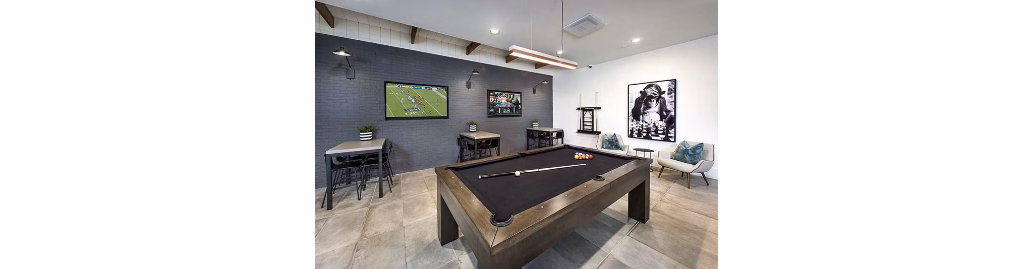 Modern game room with billiards and arcade games at The Penrose Apartments, offering luxury entertainment options in vibrant city living
