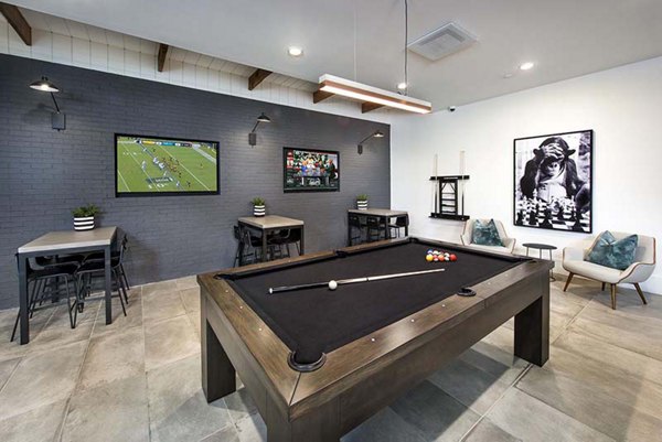 Modern game room with billiards and arcade games at The Penrose Apartments, offering luxury entertainment options in vibrant city living