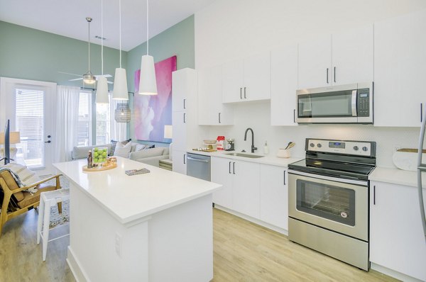 Modern kitchen with stainless steel appliances in The Penrose Apartments