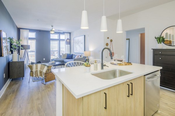 Modern kitchen featuring stainless steel appliances and granite countertops at The Penrose Apartments