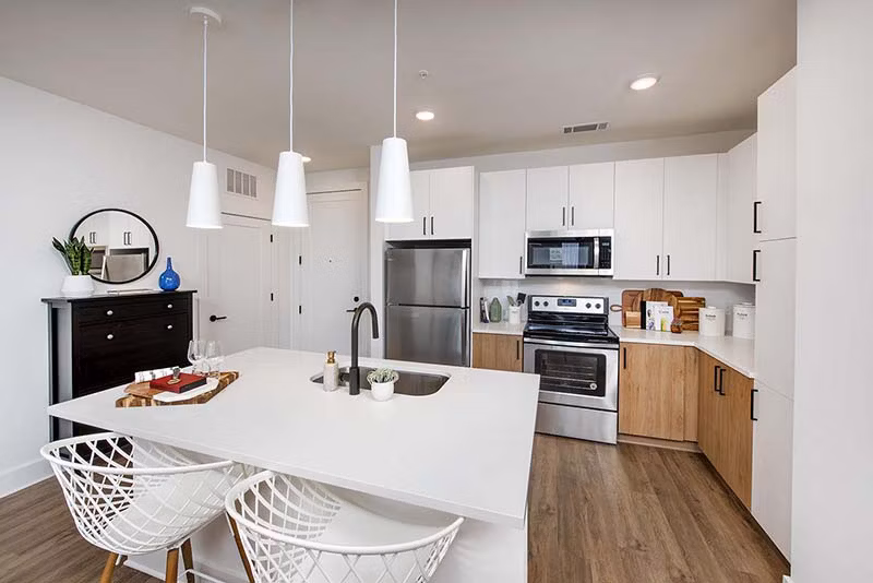 Modern kitchen with stainless steel appliances and sleek countertops at The Penrose Apartments, luxury living in a stylish setting