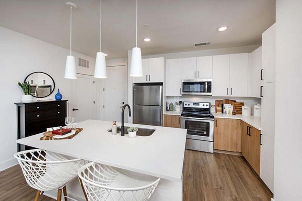 Modern kitchen with stainless steel appliances and sleek countertops at The Penrose Apartments, luxury living in a stylish setting