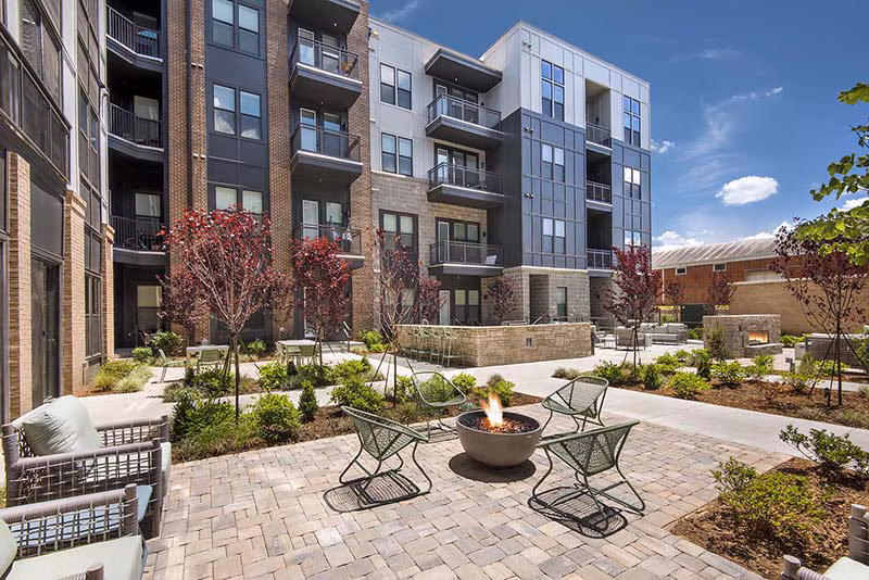 Fire pit lounge area with seating at The Penrose Apartments offering luxury evening relaxation