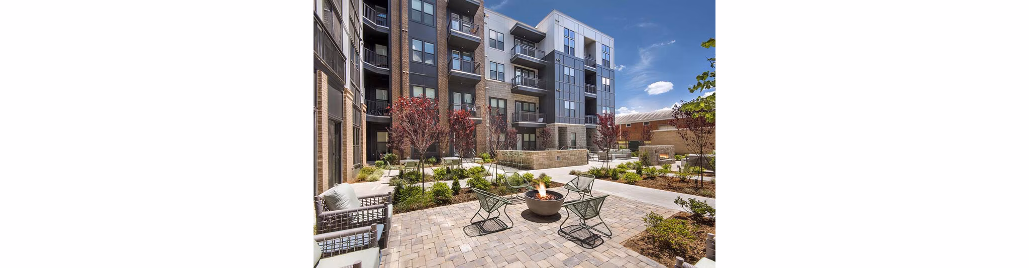 Fire pit lounge area with seating at The Penrose Apartments offering luxury evening relaxation