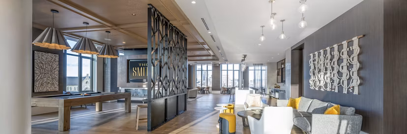 Modern clubhouse with stylish seating and expansive windows at The Smith Apartments, offering a vibrant community space for relaxation and socializing