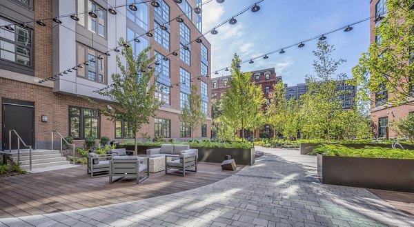 Charming patio with cozy seating in the courtyard at The Smith Apartments, ideal for outdoor relaxation and social gatherings