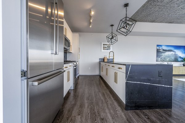 Modern kitchen with sleek cabinetry and stainless-steel appliances in Imprint Apartments, Greystar luxury apartments in a vibrant urban setting