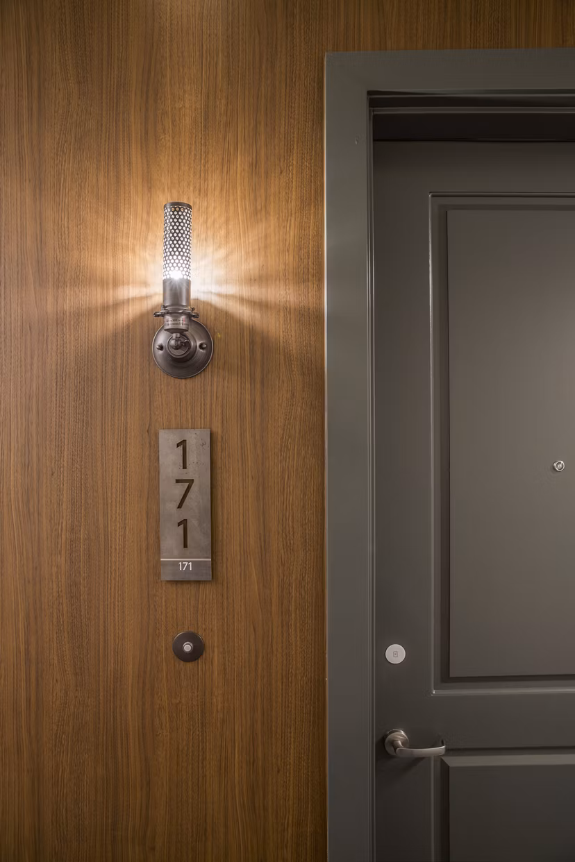 Hallway with modern lighting and wood flooring at The Griffith Apartments