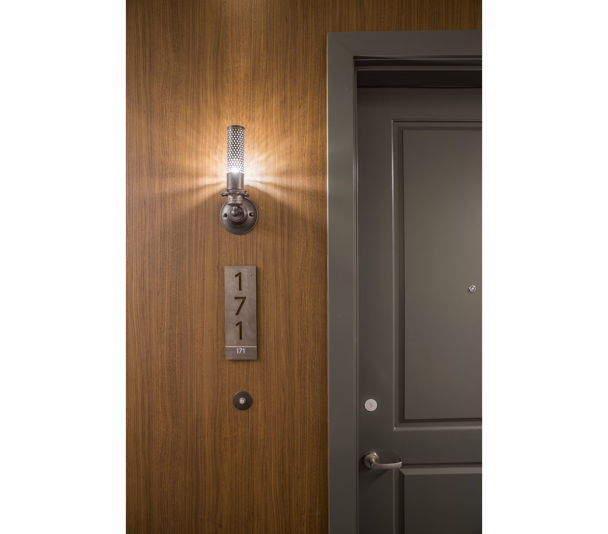 Hallway with modern lighting and wood flooring at The Griffith Apartments