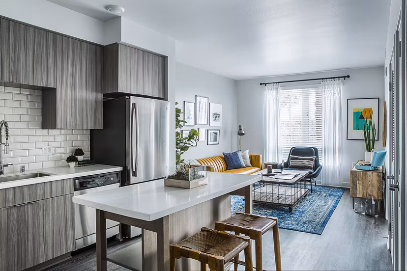 Modern kitchen with stainless steel appliances and island counter at The Griffith Apartments