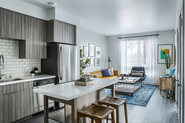 Modern kitchen with stainless steel appliances and island counter at The Griffith Apartments