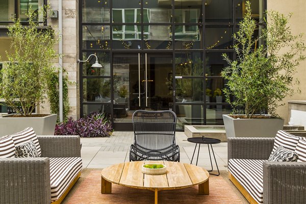 The Griffith Apartments: Serene courtyard with lush greenery and modern seating, ideal for relaxation