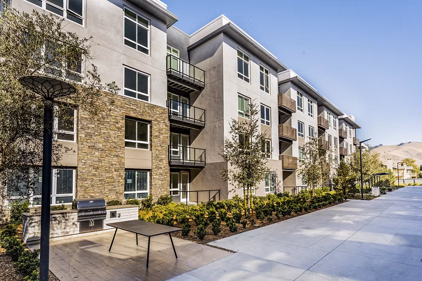 Outdoor grill area at The Asher Apartments featuring modern BBQ stations and ample seating for residents to enjoy in a communal setting