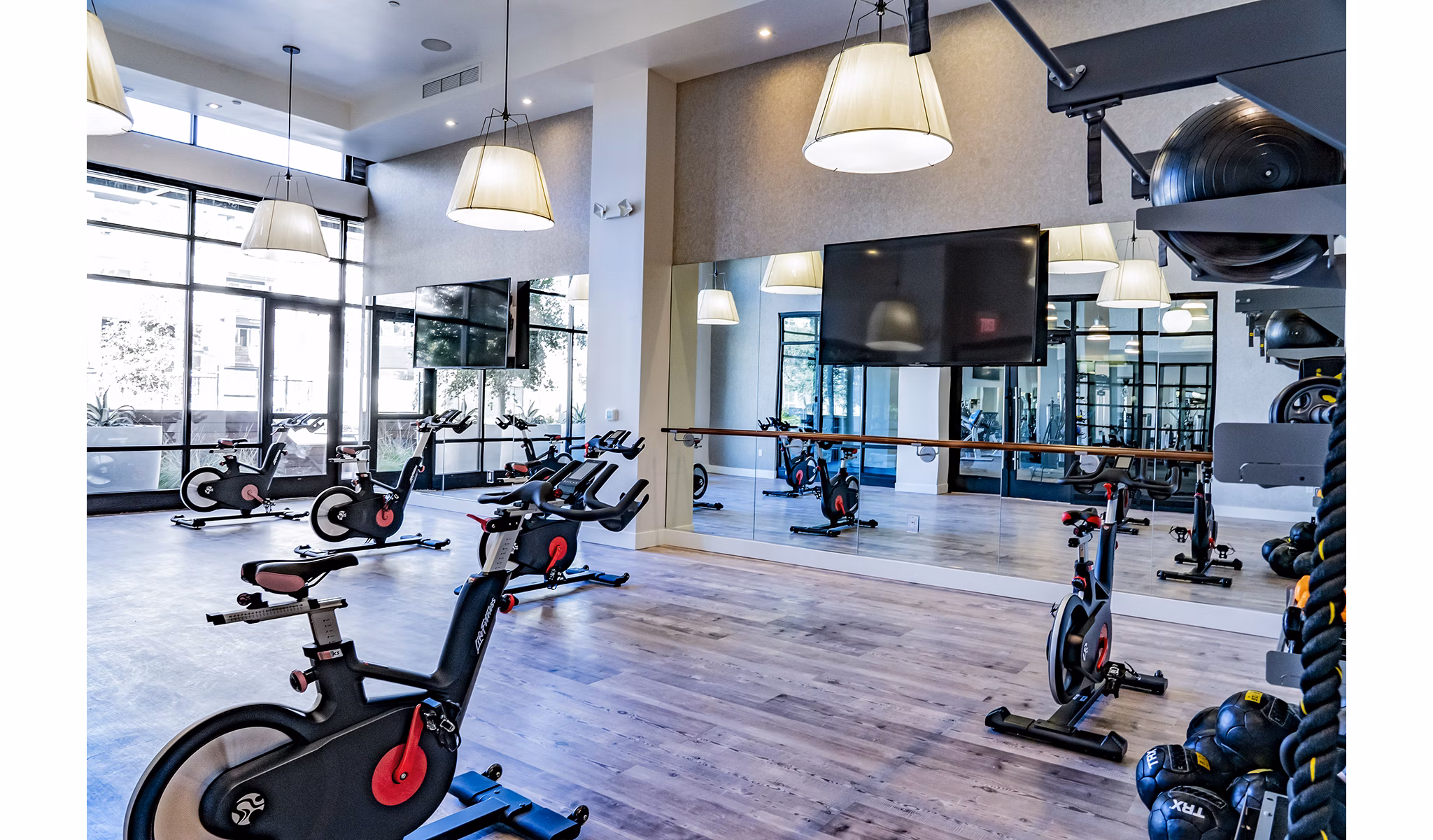 Yoga and spin studio with modern equipment at The Asher Apartments, promoting active lifestyle and fitness options for residents