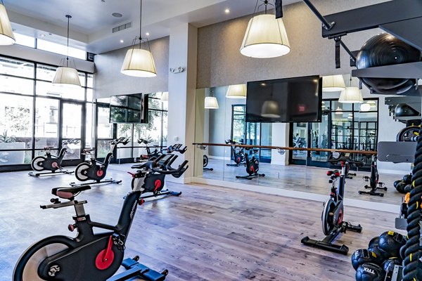 Yoga and spin studio with modern equipment at The Asher Apartments, promoting active lifestyle and fitness options for residents