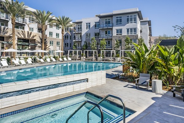 Modern outdoor pool with lounge chairs at The Asher Apartments in the  community