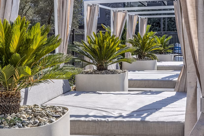 Spacious pool patio with lounge seating at The Asher Apartments offering luxury outdoor amenities in an elegant setting