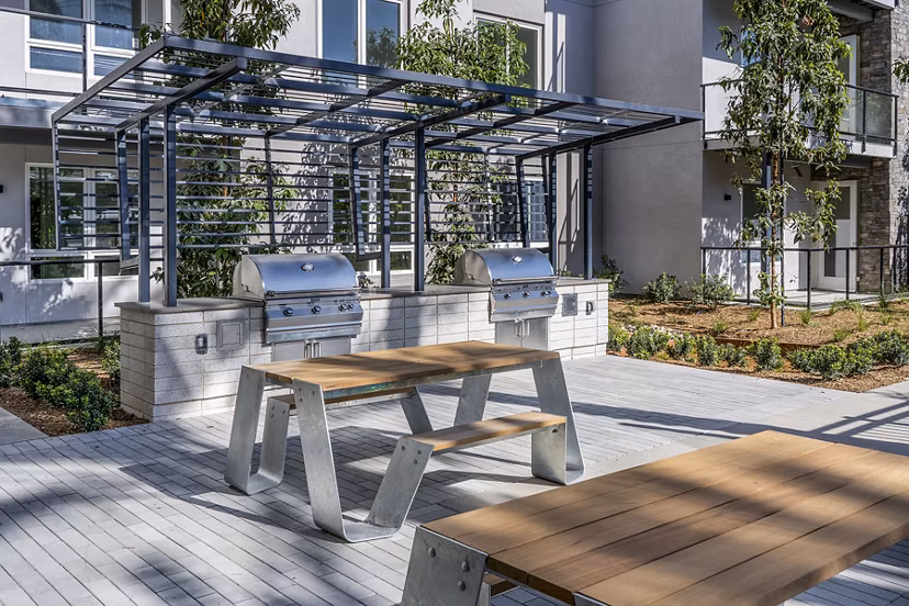 Outdoor grill area with modern seating at The Asher Apartments, offering a luxury amenity for social gatherings and dining experiences