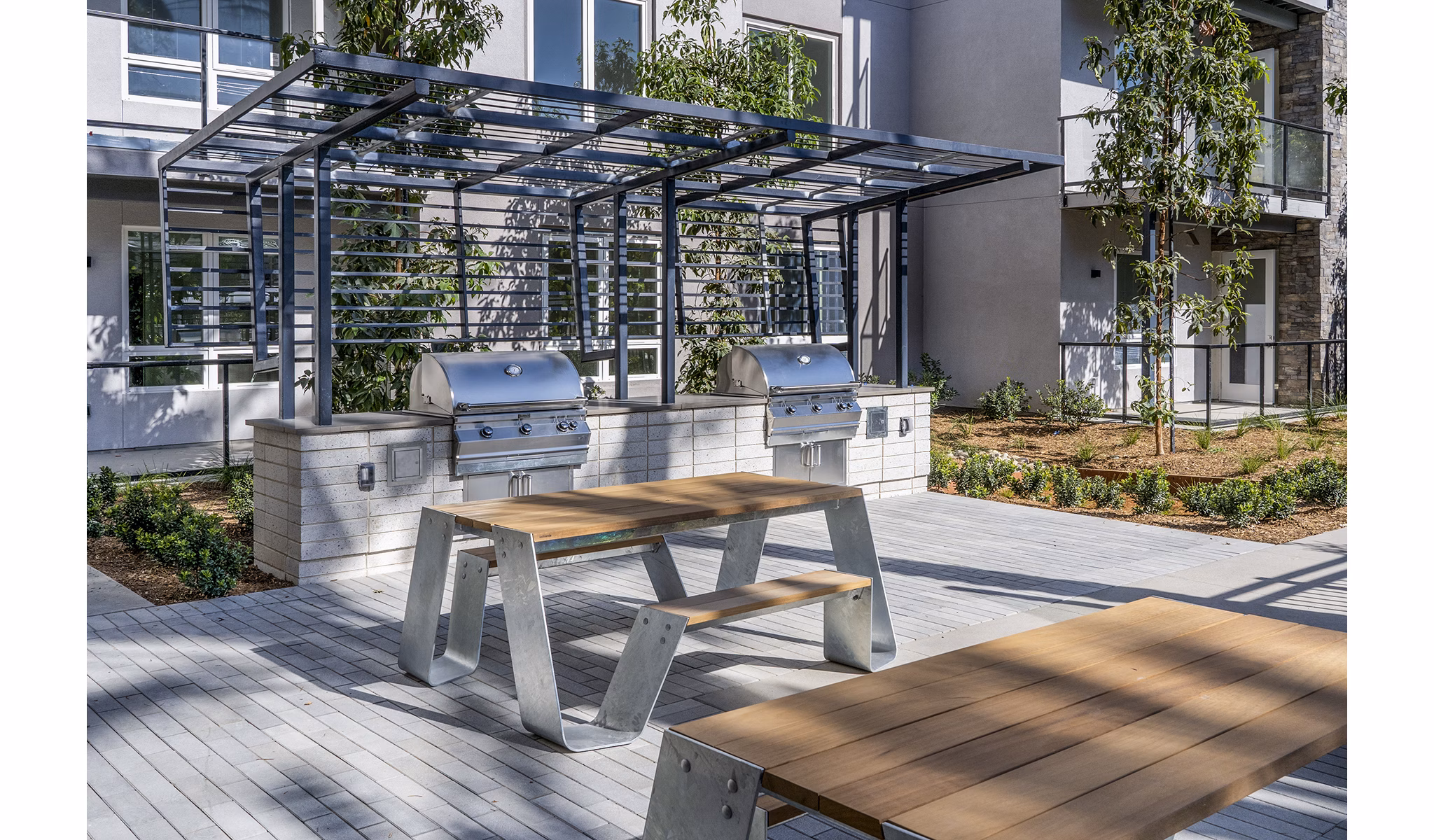 Outdoor grill area with modern seating at The Asher Apartments, offering a luxury amenity for social gatherings and dining experiences