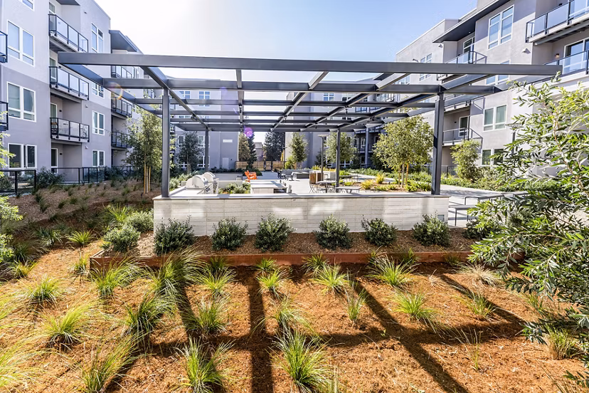 Grill area with modern barbecue stations at The Asher Apartments' luxury outdoor kitchen