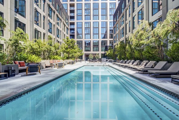 Infinity pool with sun deck at Atlas Apartments offering luxury relaxation options