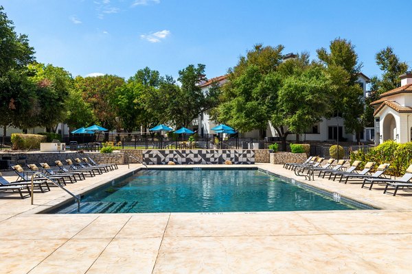 Resort-style pool with lounge chairs at Mesa Verde Apartments
