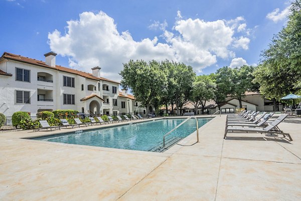 Resort-style pool with sun loungers at Mesa Verde Apartments