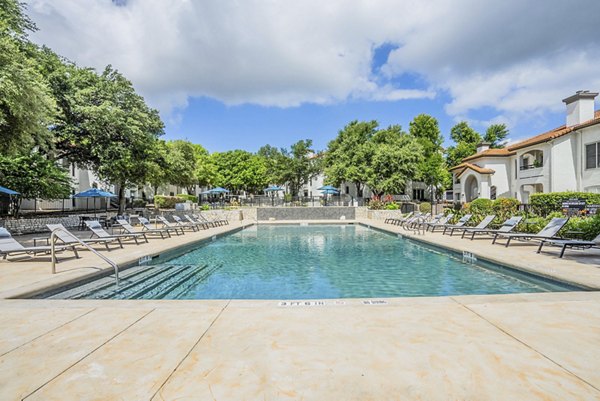 Resort-style outdoor pool at Mesa Verde Apartments, featuring palm trees and lounge areas, creating a luxury living experience in a tranquil setting