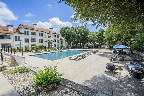 Resort-style pool with lounge chairs at Mesa Verde Apartments