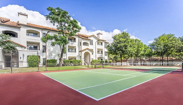 Tennis court with clear blue skies at Mesa Verde Apartments, offering luxury outdoor sports facilities in a serene community setting