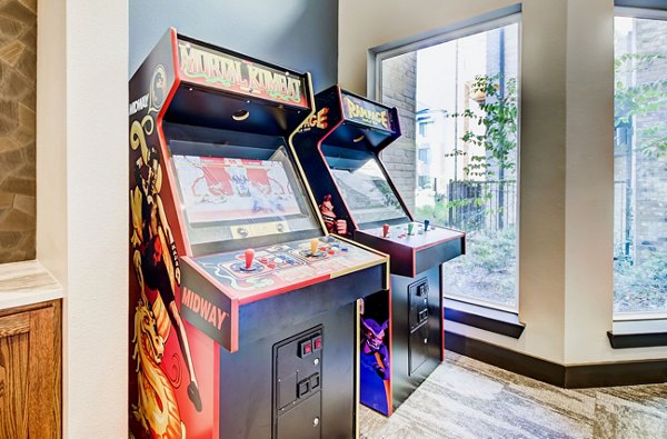 Game room with pool table and arcade games in Lenox Reserve Apartments