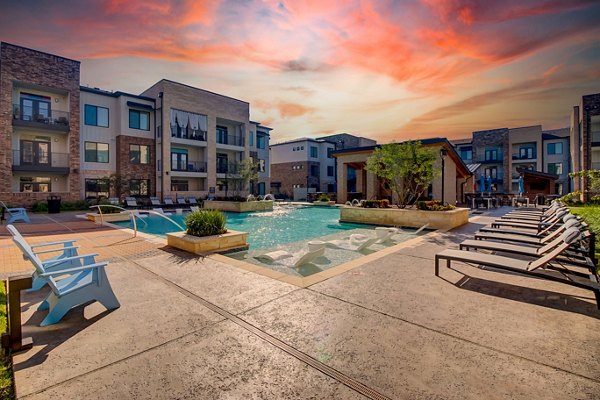 Luxurious pool area at Lenox Reserve Apartments with sun loungers and lush landscaping