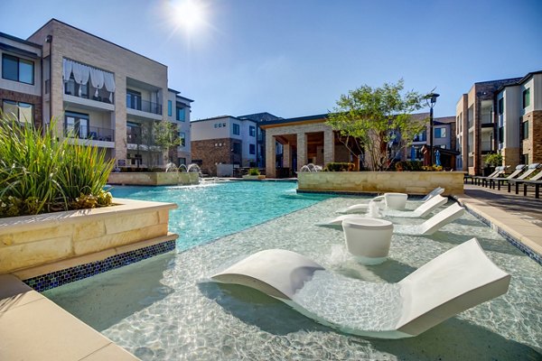 Serene pool area with lounge chairs at Lenox Reserve Apartments, offering luxury living amenities and relaxation spaces in a lush setting