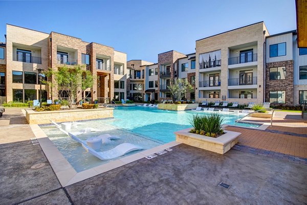 Resort-style pool with lounge chairs at Lenox Reserve Apartments, offering luxury amenities in a vibrant community setting