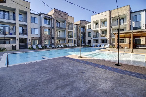 Luxurious pool with surrounding lounge chairs at Lenox Reserve Apartments, ideal for relaxation and social gatherings in a serene setting