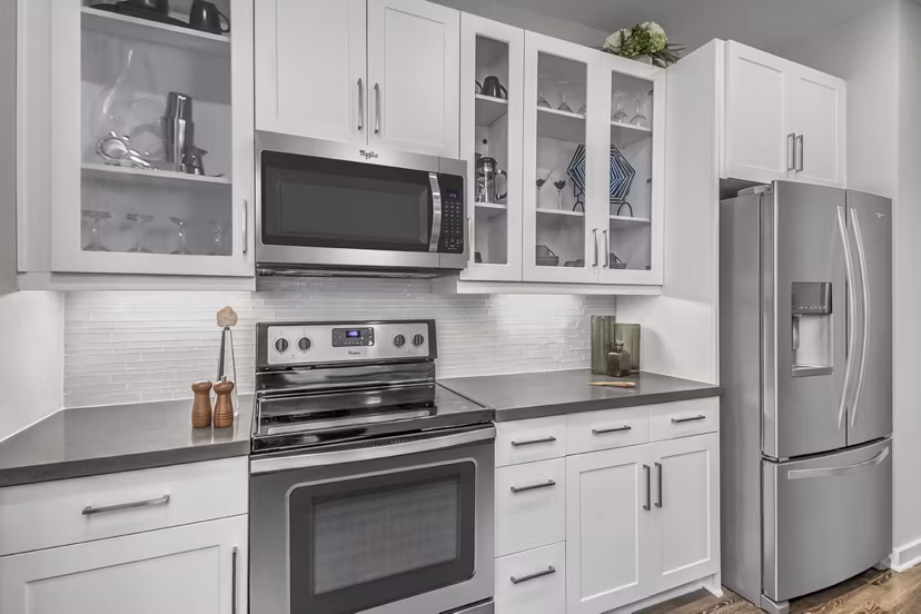 Modern kitchen with granite countertops and stainless steel appliances at Bainbridge South End Apartments