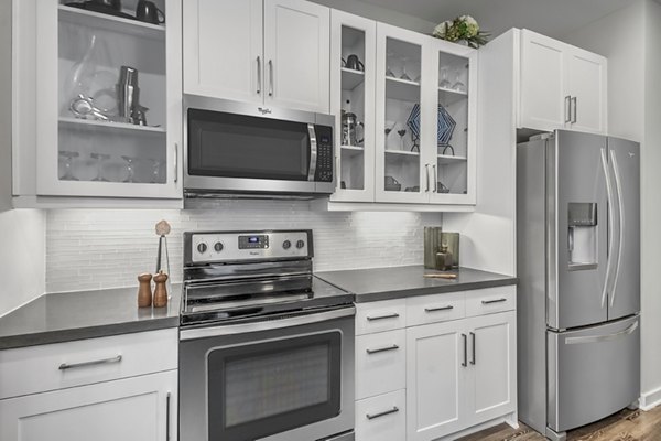 Modern kitchen with granite countertops and stainless steel appliances at Bainbridge South End Apartments