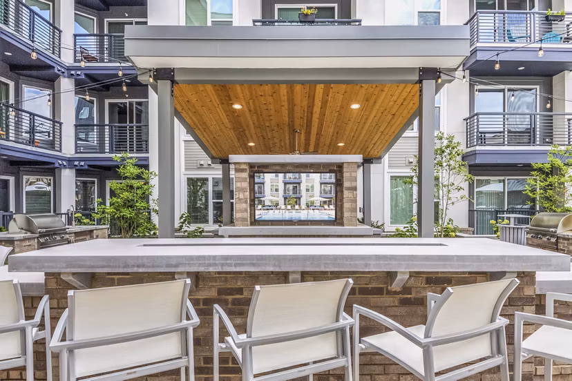 Patio with comfortable seating and lush greenery at Bainbridge South End Apartments