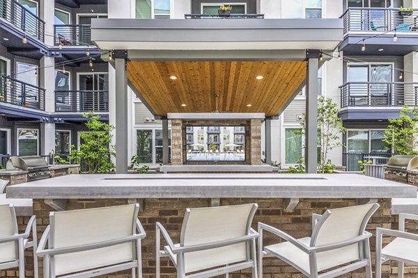 Patio with comfortable seating and lush greenery at Bainbridge South End Apartments