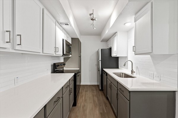 Modern kitchen with marble countertops and stainless steel appliances in The Haven Apartments