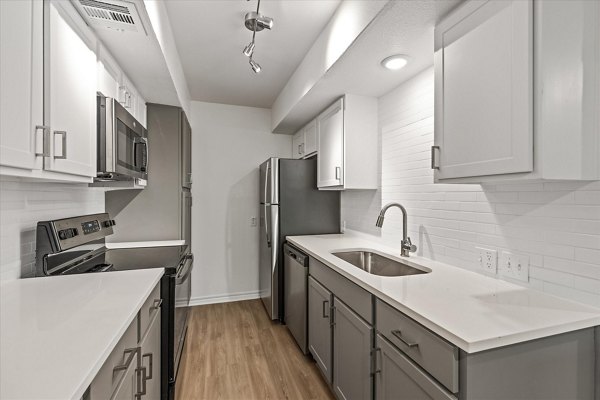 Modern kitchen with stainless steel appliances and sleek countertops in The Haven Apartments